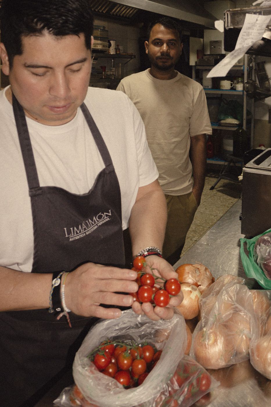 El cocinero escoge tomates en la cocina de Lima Limón