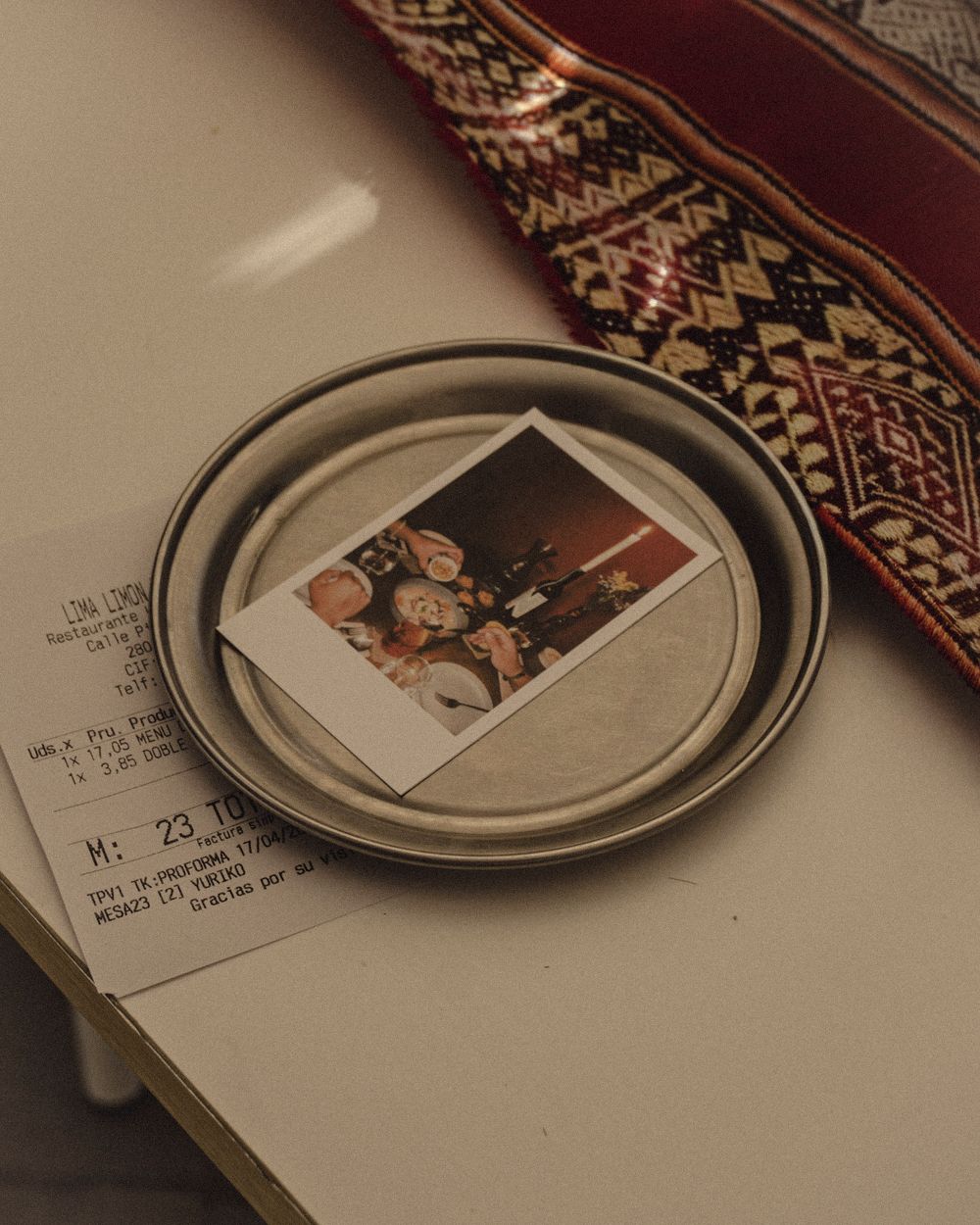 Polaroid y cuenta sobre un aguayo